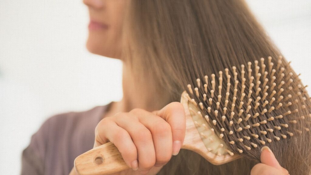 a woman with alopecia brushing her hair after having PRP and PRF done. Cleveland, Body Tonic, Medspa