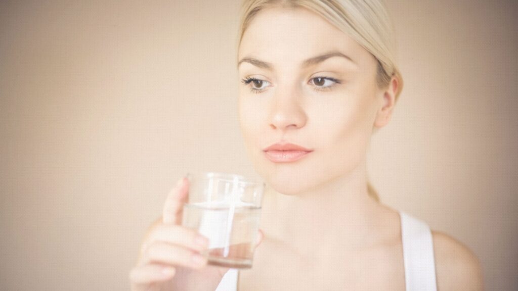 Image of a woman drinking a glass of water, supporting her weight-loss journey with semaglutide by staying hydrated and practicing healthy habits.