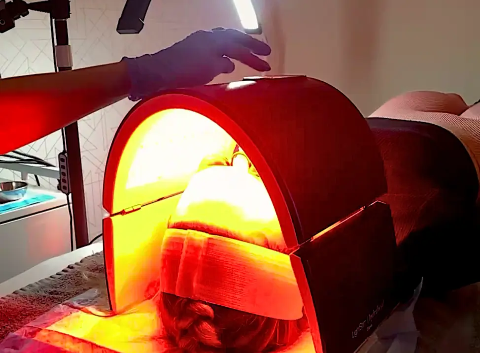 Client receiving an LED light therapy facial treatment at Bodytonic Medspa in Cleveland, OH. The red light therapy helps reduce inflammation, boost collagen production, and rejuvenate the skin. New client specials available.